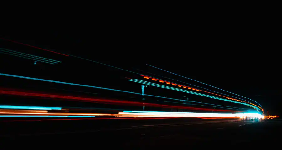 Long exposure photography capturing vibrant light streaks on a highway at night.