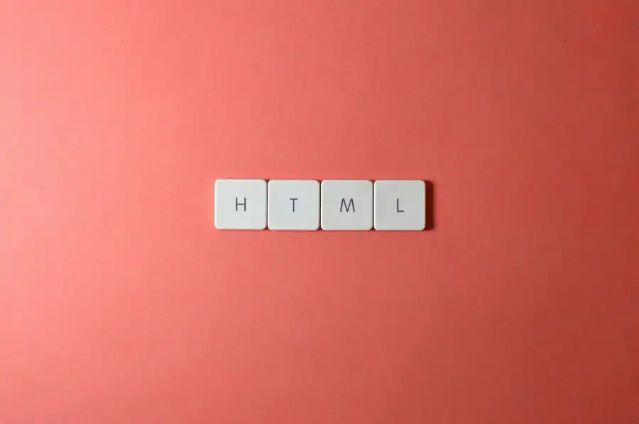 Minimalist design of HTML letter tiles on a salmon pink surface.